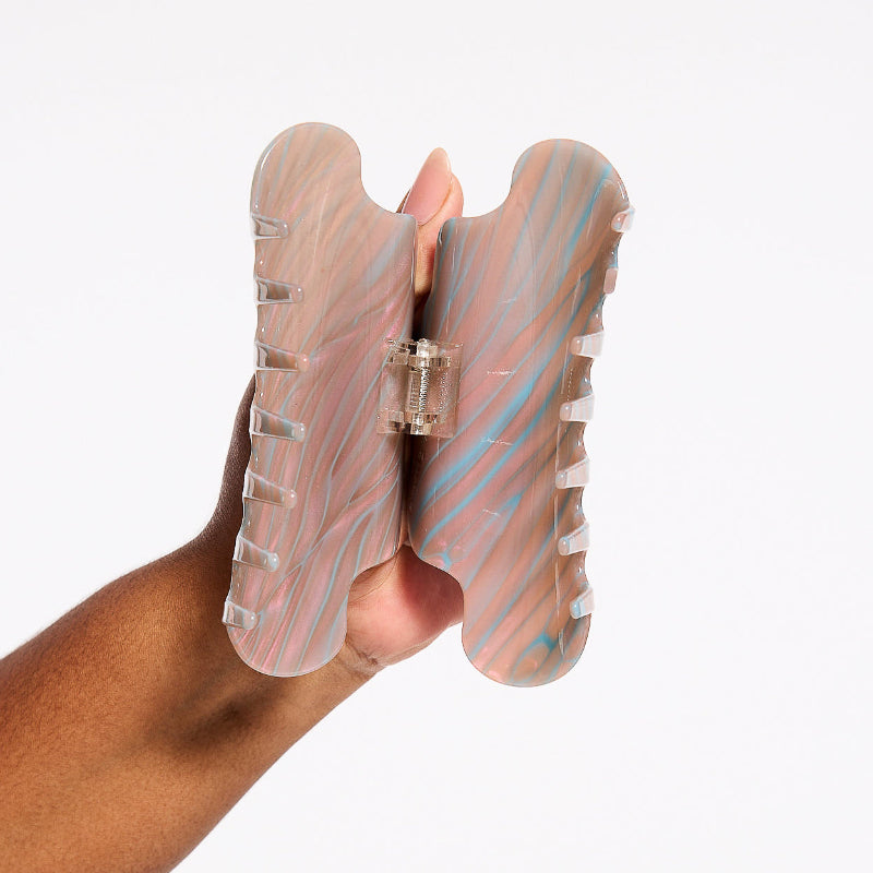 Hand holding Chunks Nimbus Hair Claw Clip in Fuel open on a white background
