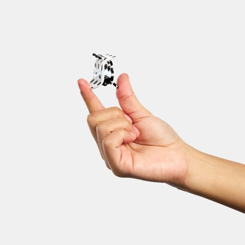 Hand holding Chunks Mini Hair Claw Clip in Black and White Strot on white background