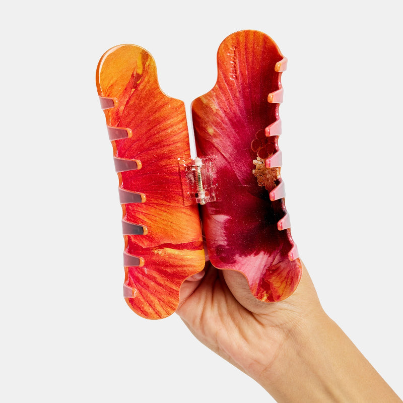 Hand holding Chunks Nimbus Hair Claw Clip in Hibiscus Flower open on a white background