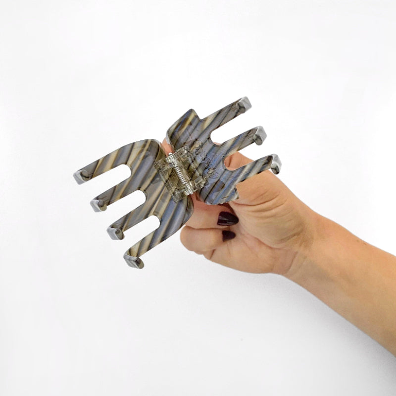 Hand holding Chunks Hair Claw Clip in Shadow open on a white background