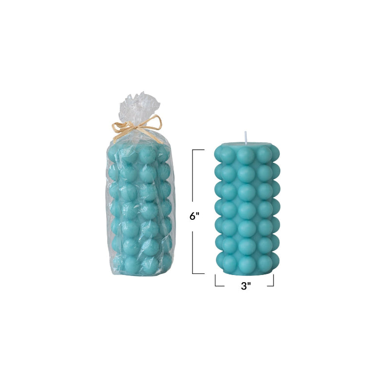 Unscented Hobnail Pillar Candle 6"H in Cyan Blue shown in cellophane packaging and without packaging. Measurements of height and width are shown in photo