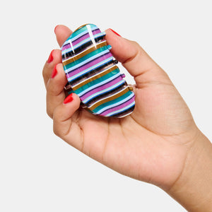 Hand holding the Chunks Juno Hair Claw Clip in Frances on a white background