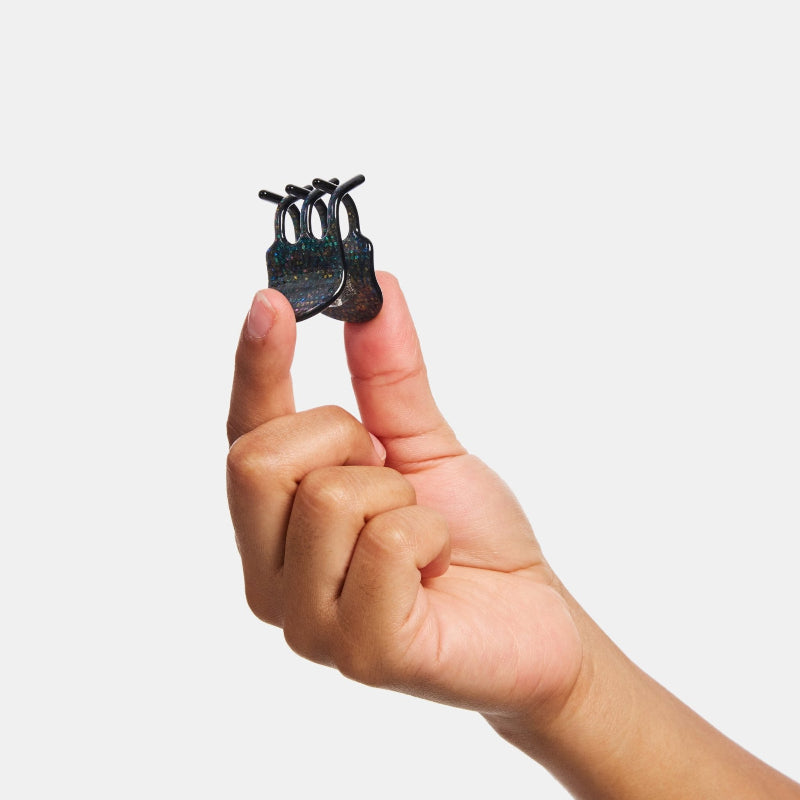 Hand holding Chunks Mini Claw Clip in Dark Sparkle on a white background