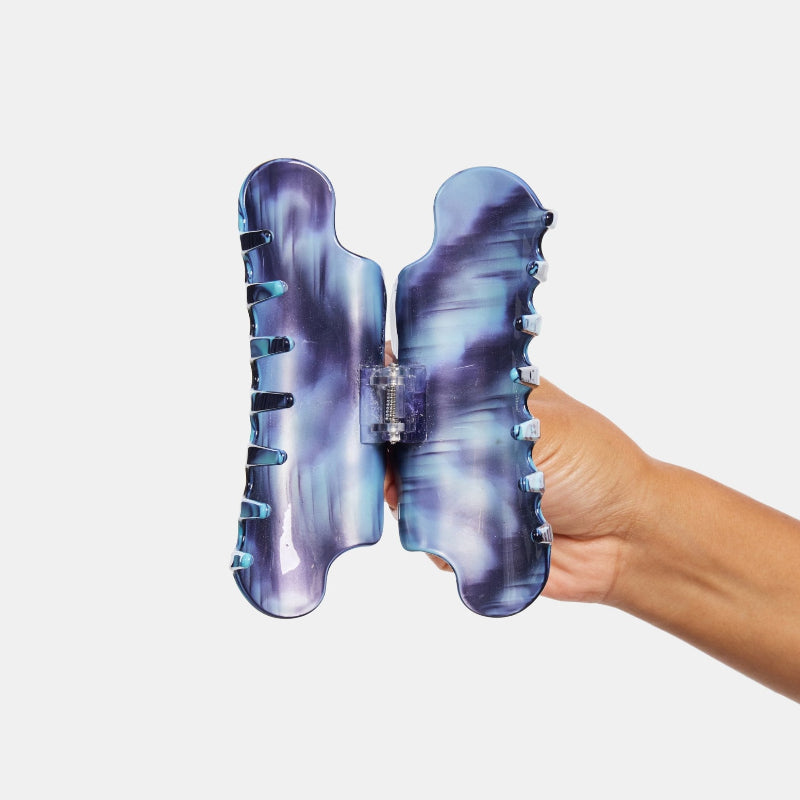 Hand holding Chunks Nimbus Hair Claw Clip in Ripple open on white background