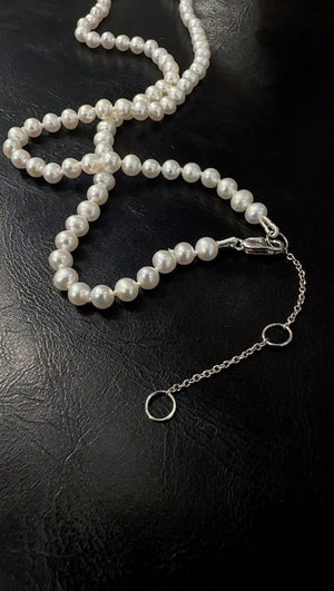 White Freshwater Pearls hand strung on silk cord with a sterling silver extension chain